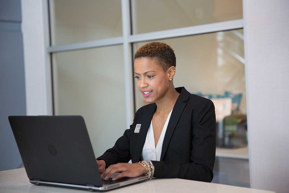 a woman sitting at a desk using a laptop