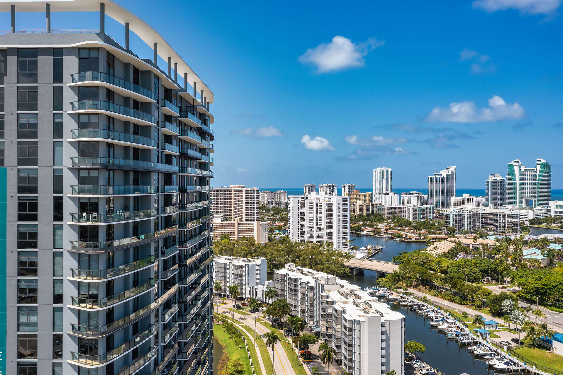 a high rise building with many balconies and a river