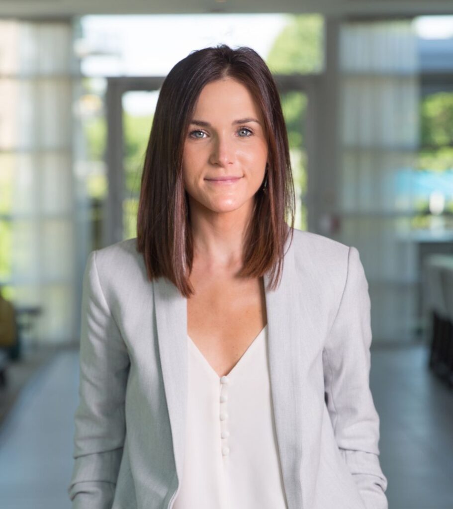 a woman in a white shirt and grey jacket