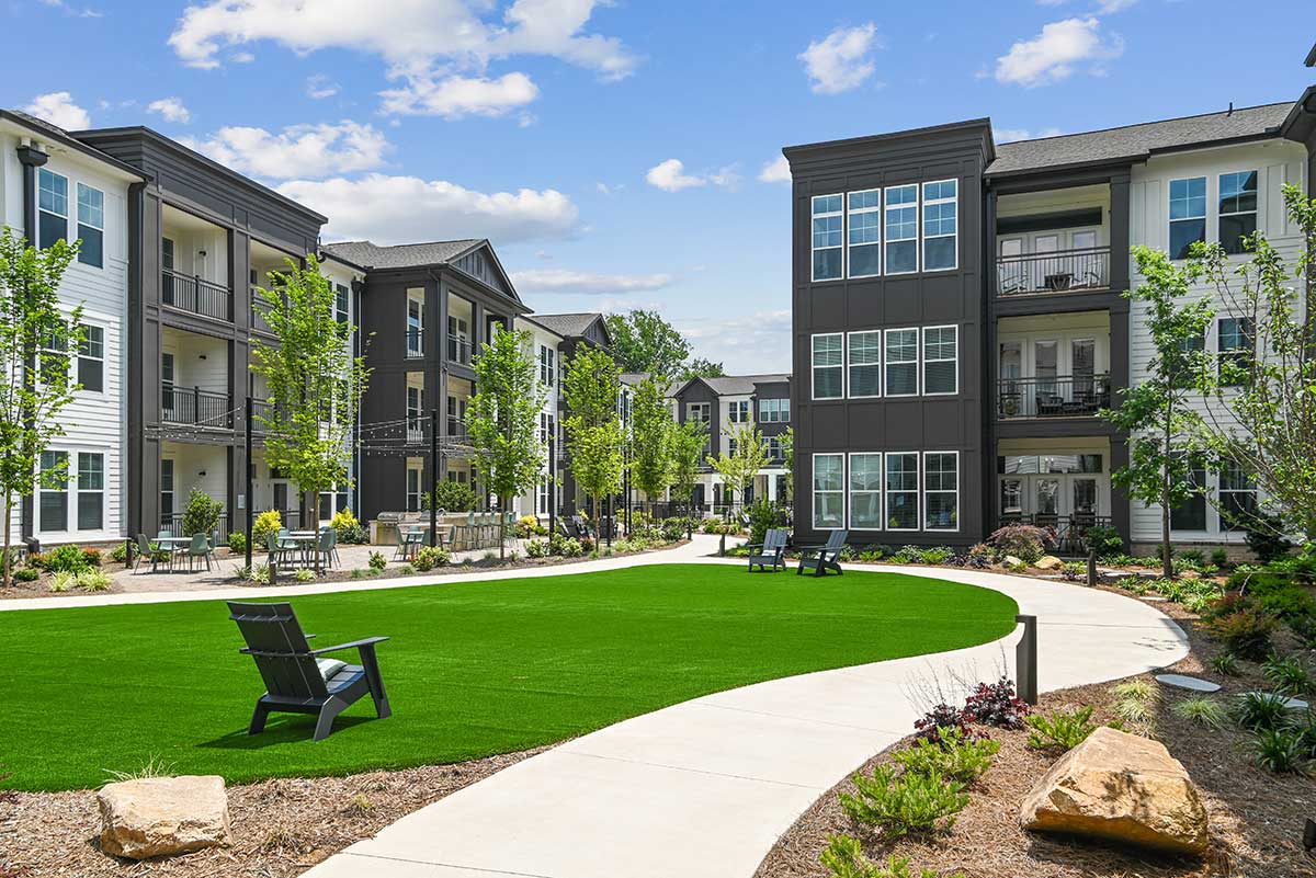 a courtyard with a lawn and chairs