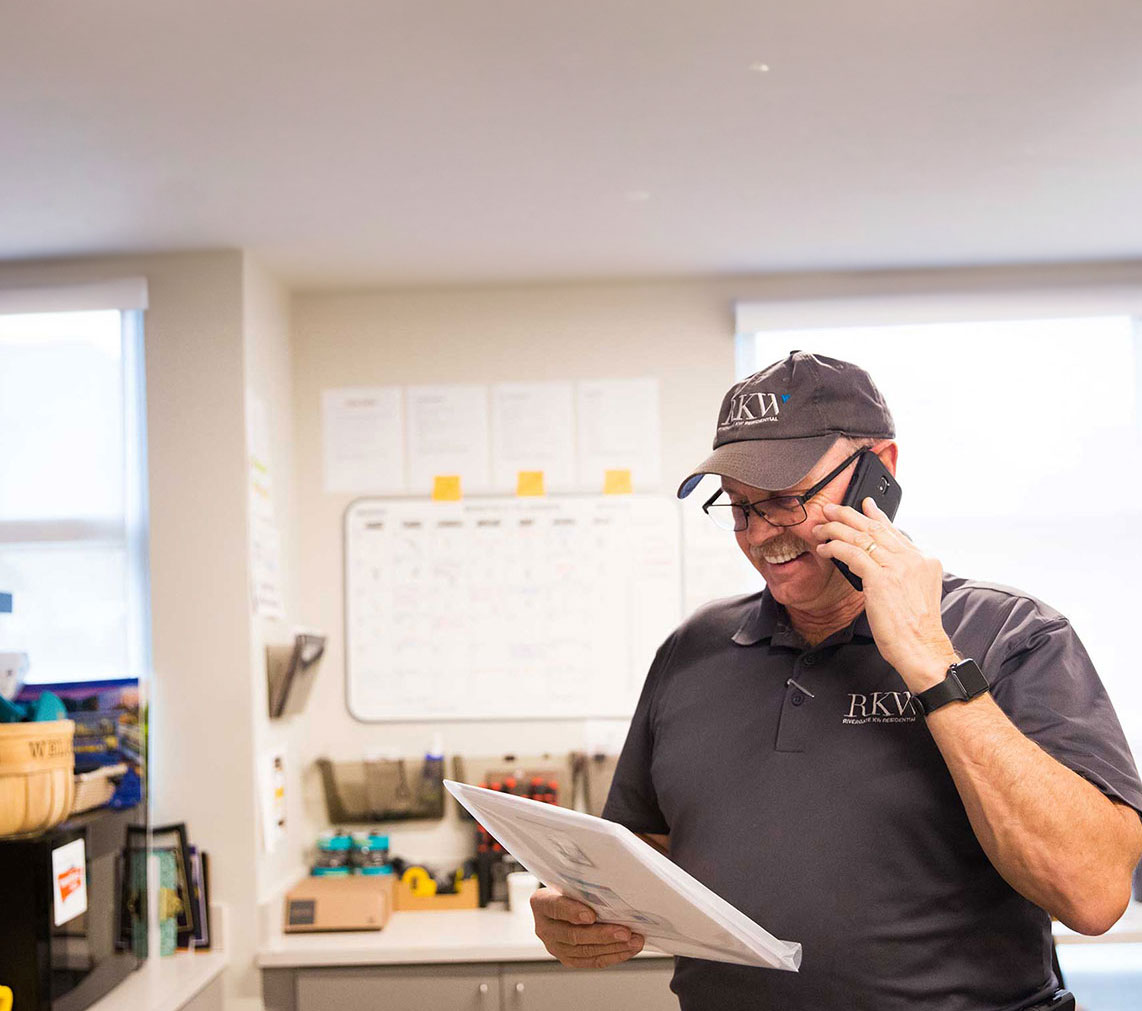 a man holding a paper and talking on a cell phone