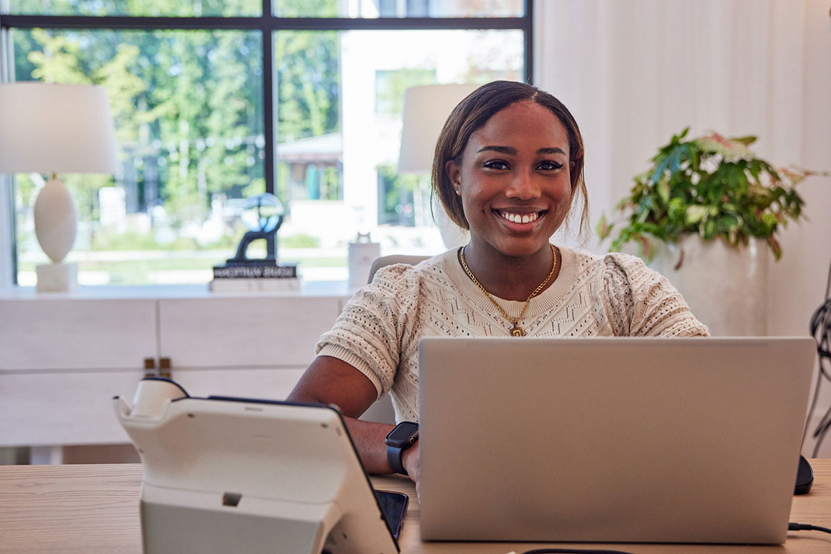 a woman sitting at a desk with a laptop