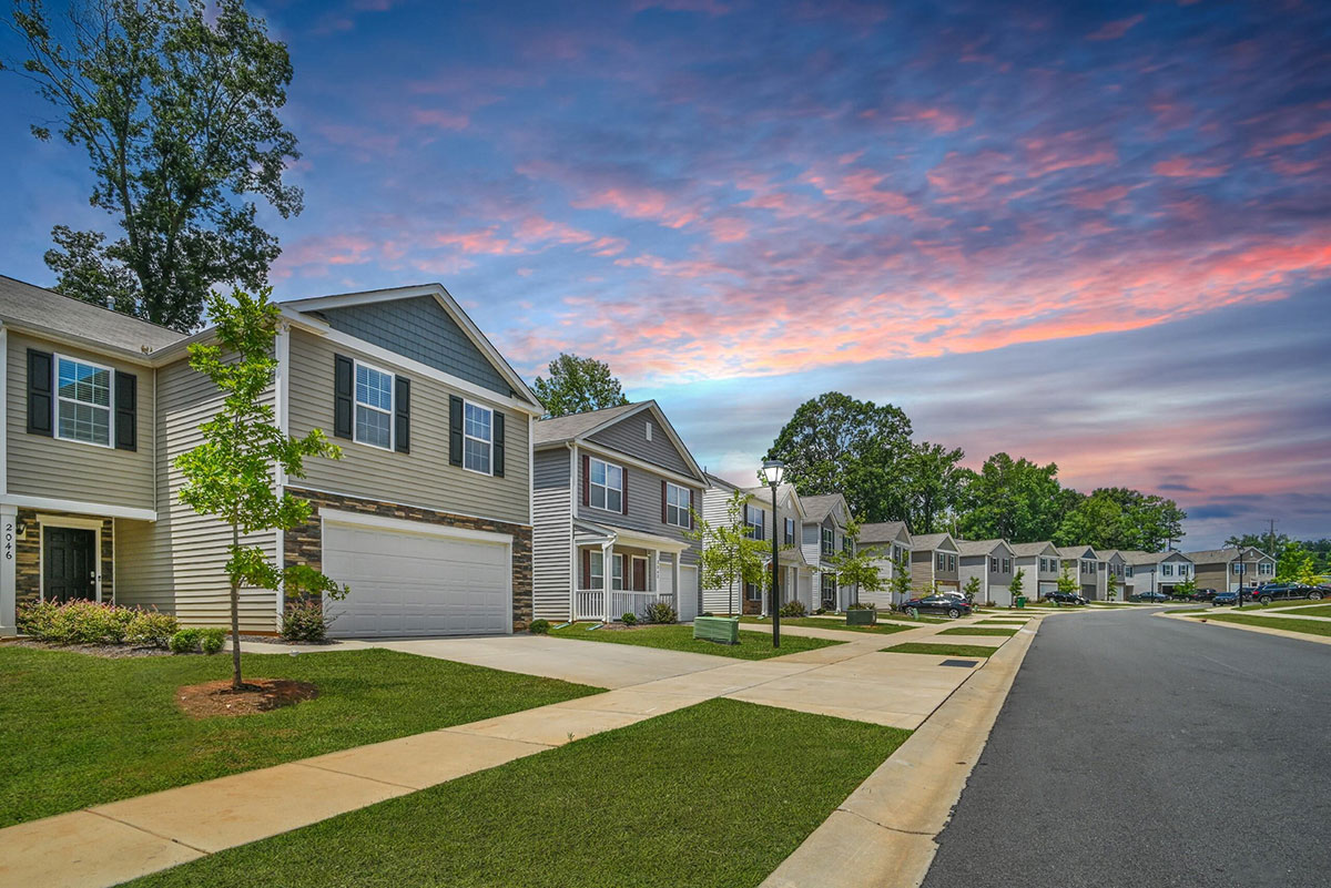 a row of houses with trees and grass