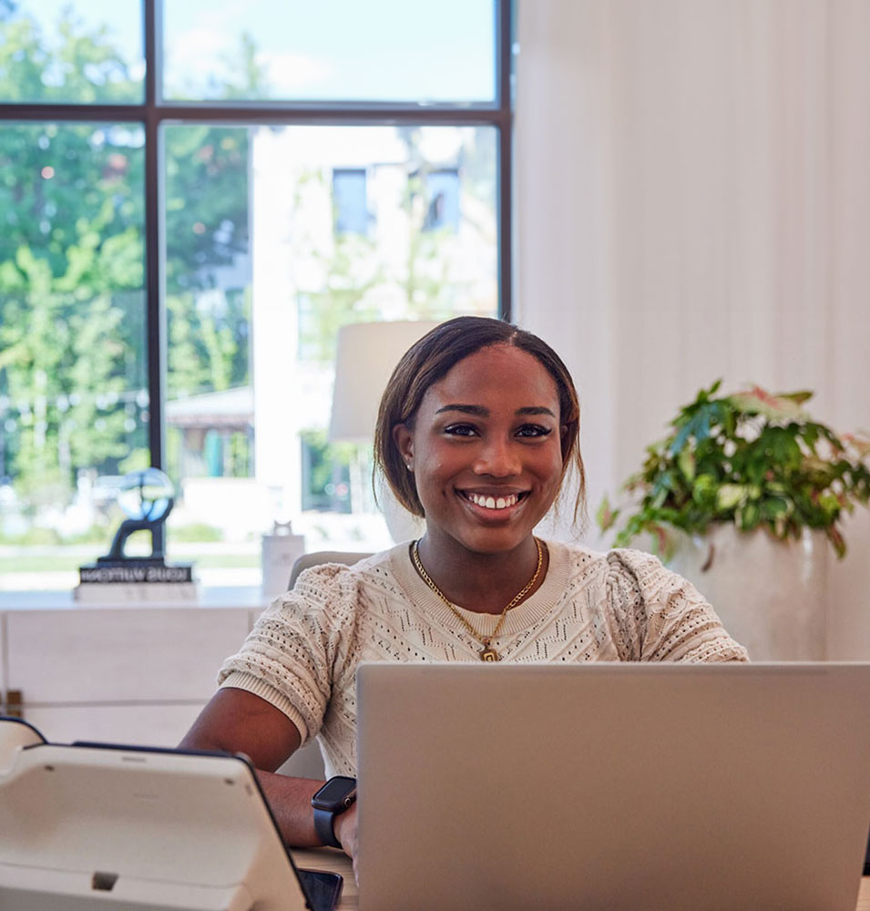 a woman sitting at a desk with a laptop