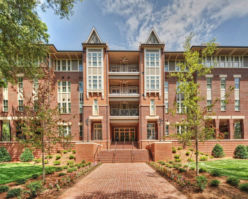 a brick building with trees and a walkway