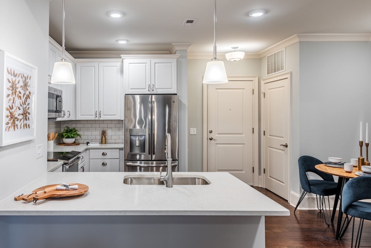 a kitchen with a stainless steel refrigerator and a chair