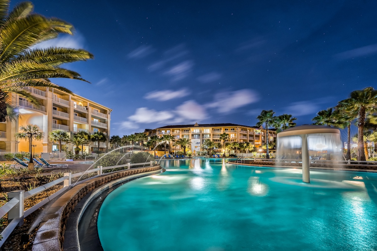 a pool with a fountain in front of a building